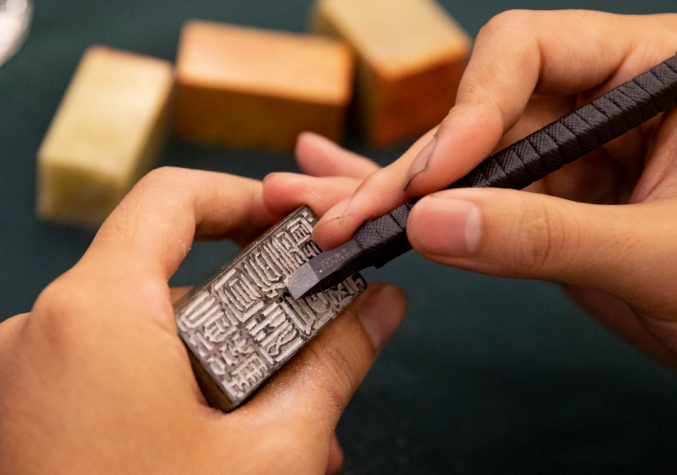 2023年10月18日,華東師范大學(xué)書(shū)法篆刻專業(yè)的學(xué)生在現(xiàn)場(chǎng)篆刻。當(dāng) 天,華東師范大學(xué)“大夏百詠”篆刻創(chuàng)作啟動(dòng)暨韓天衡獎(jiǎng)學(xué)金頒發(fā)儀式舉行。 “大夏百詠”篆刻創(chuàng)作項(xiàng)目是2023—2024年華東師范大學(xué)校園文化重點(diǎn)項(xiàng) 目,旨在傳承文脈,彰顯底蘊(yùn)。