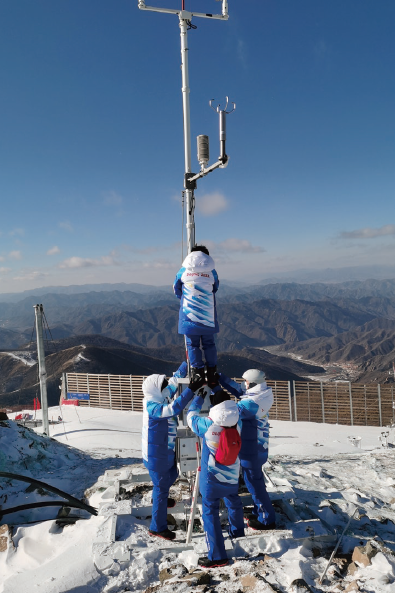 2022年1月25日，延慶賽區駐場的北京冬奧 會冬殘奧會外圍氣象服務團隊現場觀測保障人員 正在維護國家高山滑雪中心競速賽道附近的自動 氣象站。