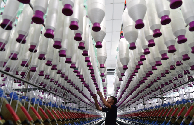 2024年7月17日，位于福州市長樂區的福建金源紡織5G智 慧工廠里，工人在生產線上作業。